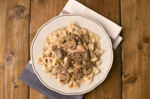 Butterfly pasta with mushrooms and parmesan sauce. Typical Italian cuisine from the south. Top view