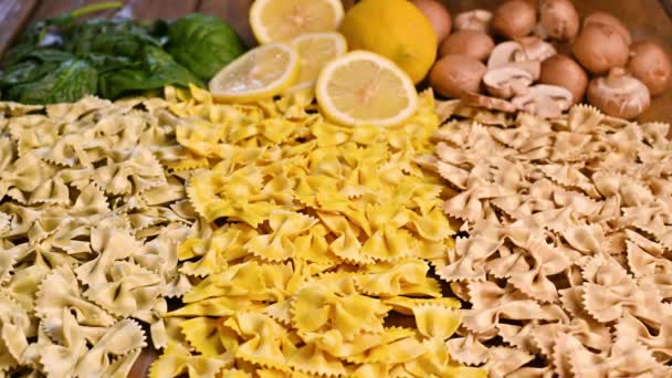 Diverses pâtes italiennes sèches. Avec des épinards, champignons et saveur de citron. La main prend des pâtes. — Video