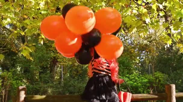 Fröhliches kleines Mädchen geht als Hexe verkleidet auf eine Party — Stockvideo