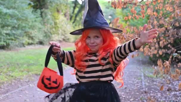 Vrolijk klein meisje verkleed als heks gaat naar een feestje — Stockvideo