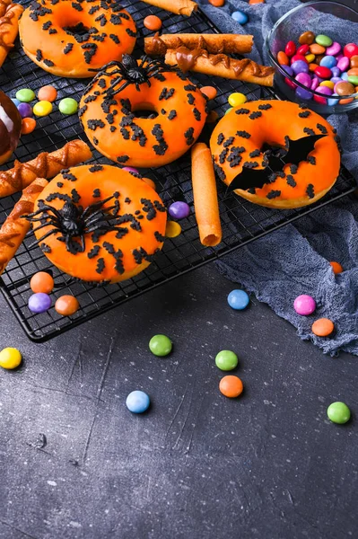 Halloween pączki na szarym tle kamienia. Słodkie ciastka urządzone na imprezę grozy. Odbiór. Widok góry. Wysokiej jakości zdjęcie — Zdjęcie stockowe