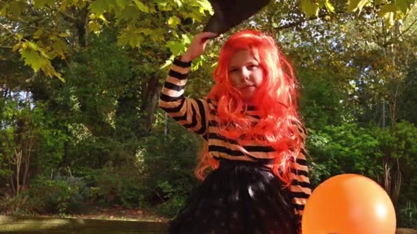 Cheerful little girl dressed as a witch is going to a party — Stock Video