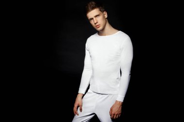 Siyah arka plan üzerine beyaz spor kıyafeti giyen erkek rahat tarzı