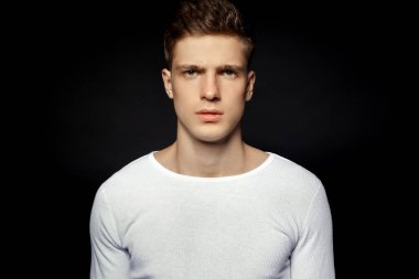 Siyah arka plan üzerine beyaz spor kıyafeti giyen erkek rahat tarzı