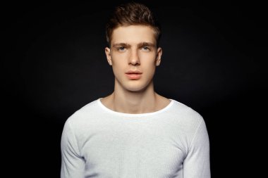 Siyah arka plan üzerine beyaz spor kıyafeti giyen erkek rahat tarzı