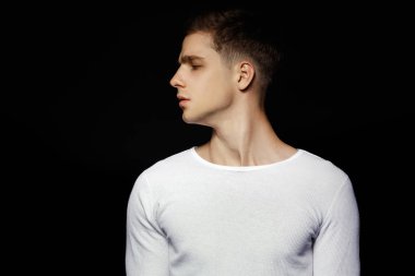 Siyah arka plan üzerine beyaz spor kıyafeti giyen erkek rahat tarzı