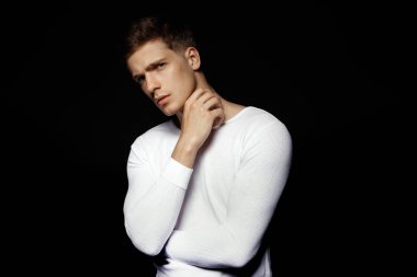 Siyah arka plan üzerine beyaz spor kıyafeti giyen erkek rahat tarzı