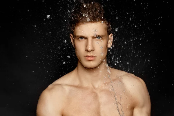 Wet topless sport guy portrait in water splash and drops