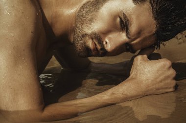 Güçlü yüz erkek model kum ve güneşin sahilde su doğa zemin üzerine