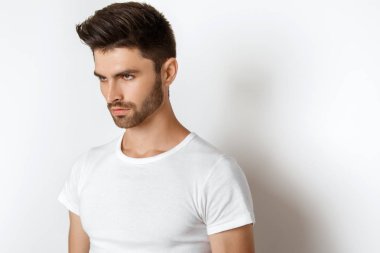 Beyaz t sirt ve izole Studio beyaz arka plan üzerinde kot rahat tarzı güçlü yüz erkek modeli