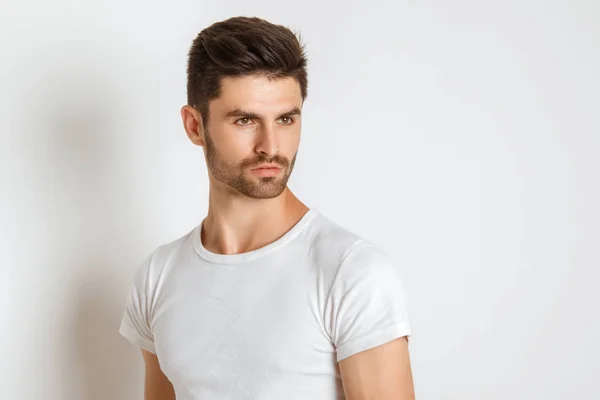 Strong face male model in casual style in white t sirt and jeans on white background in studio isolated