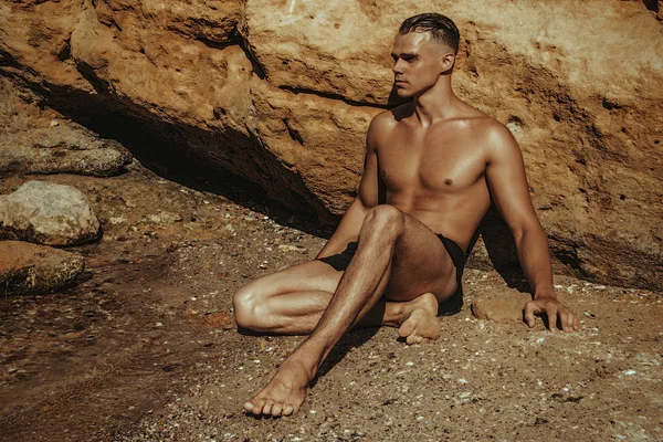 Сильный Мускулистый Мужчина Модель Фоне Природы Песчаными Скалами Водой Пляже — стоковое фото