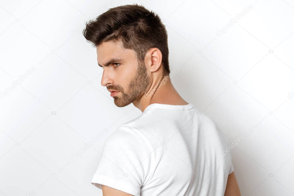 Strong face male model in casual style in white t sirt and jeans on white background in studio isolated