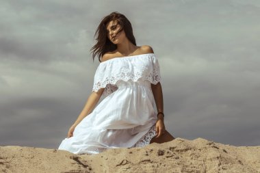 Güzel kız modeli esmer dağ ve tatlı bir elbise içinde kum yazı tipi