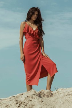 Güzel kız modeli esmer dağ ve tatlı bir elbise içinde kum yazı tipi