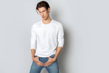 Beyaz t sirt ve izole Studio beyaz arka plan üzerinde kot rahat tarzı güçlü yüz erkek modeli
