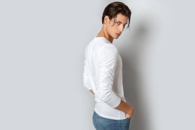 Beyaz t sirt ve izole Studio beyaz arka plan üzerinde kot rahat tarzı güçlü yüz erkek modeli