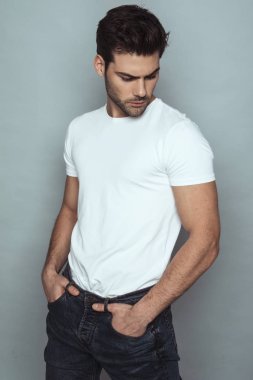 Kas gücü, kot pantolonlu, gri izole font arka planda beyaz tişörtlü güzel erkek manken.