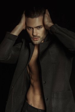 Kas gücü siyah toksinli erkek modeli ve izole yazı tipi arka planında siyah pantolon.