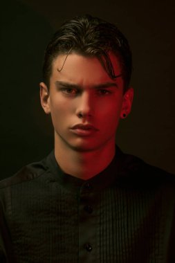 Siyah gömlekli, siyah pantolonlu ve siyah izole yazı tipli güçlü erkek modeli.