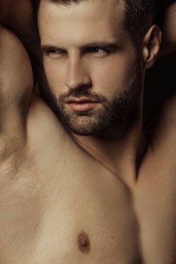 Yakışıklı seksi erkek portresi su damlalarıyla izole edilmiş siyah arka planda.