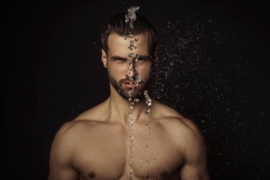 Yakışıklı seksi erkek portresi su damlalarıyla izole edilmiş siyah arka planda.