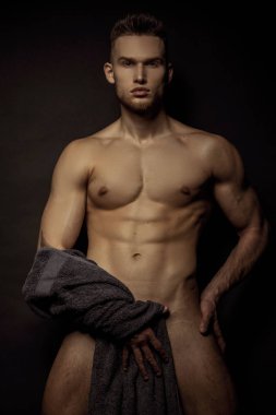 Yakışıklı seksi erkek portresi su damlalarıyla izole edilmiş siyah arka planda.