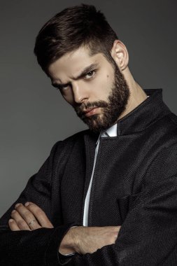 Kaslı, sakallı, güzel, soyulmuş, resmi görünümlü, gömleği ve takım elbisesi gri, izole yazı tipi arka planında.