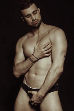 Kaslı, sakallı, güzel, siyah iç çamaşırlı, siyah izole yazı tipi arka planlı erkek model.