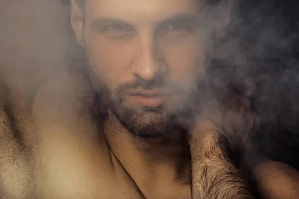 Handsome sport sexy stripped guy portrait in water drops on isolated black background