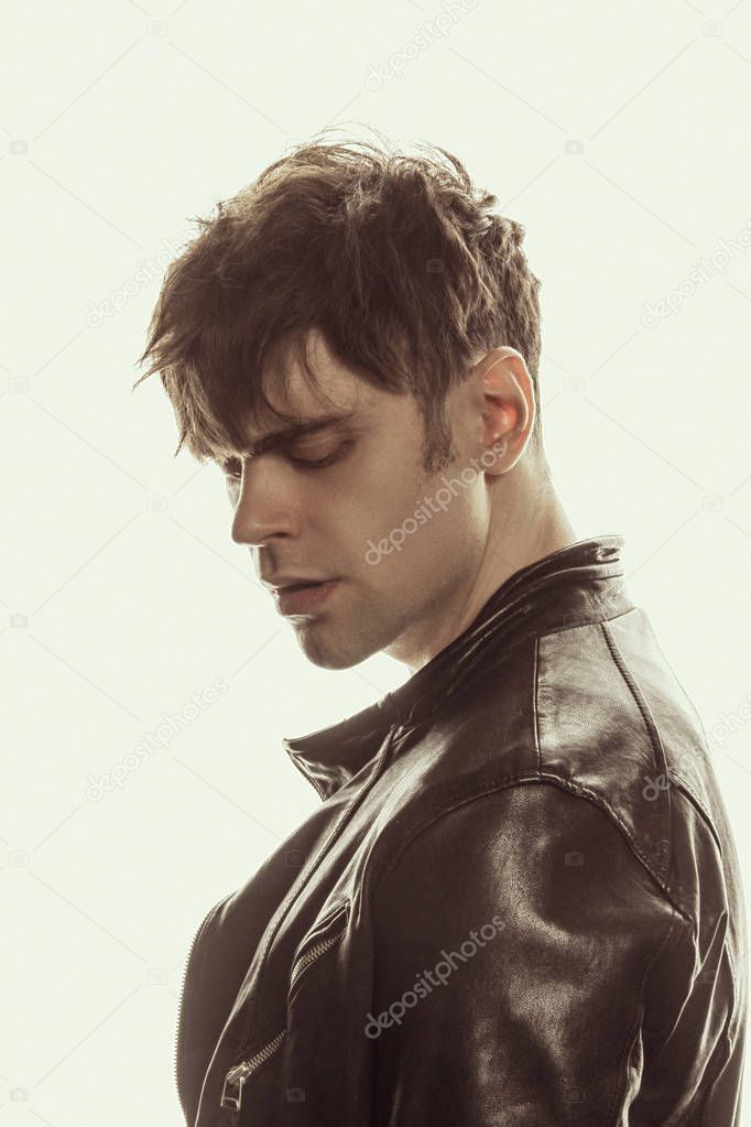 Strong stripped muscle male model in casual look in black leather jacket on white isolated font background