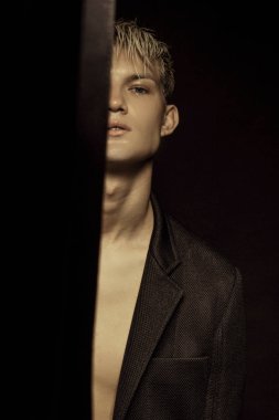 Yakışıklı siyah izole yazı tipi arka plan üzerinde siyah takım elbise giyen sarışın erkek model