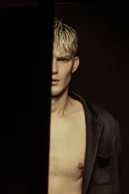 Yakışıklı siyah izole yazı tipi arka plan üzerinde siyah takım elbise giyen sarışın erkek model