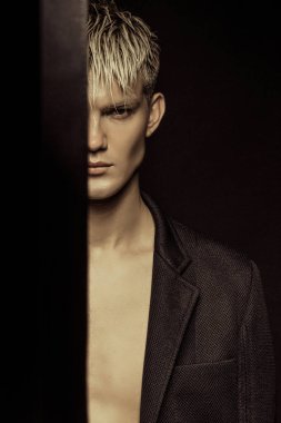 Yakışıklı siyah izole yazı tipi arka plan üzerinde siyah takım elbise giyen sarışın erkek model