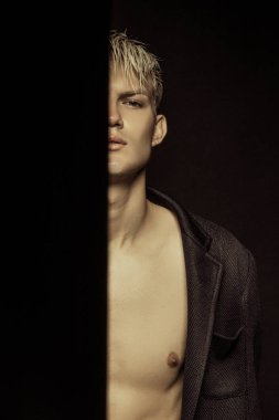 Yakışıklı siyah izole yazı tipi arka plan üzerinde siyah takım elbise giyen sarışın erkek model