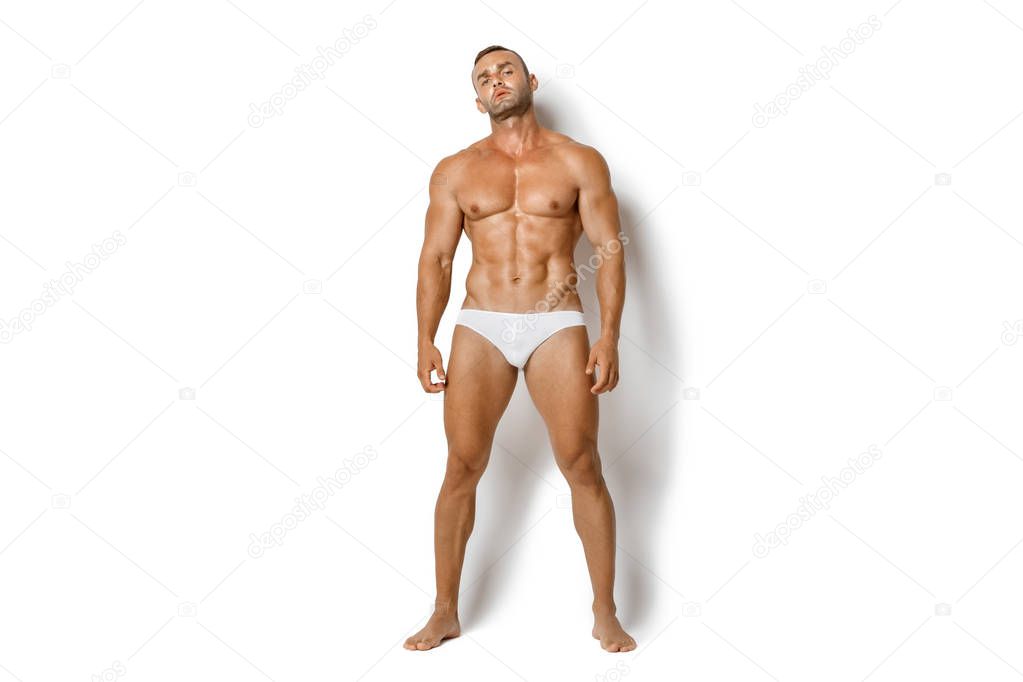 Strong stripped muscle male model in white underwear on white isolated font background