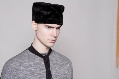 Beyaz izole yazı tipi arka plan üzerinde moda cloathes ve şapka güzel güçlü yüz erkek modeli