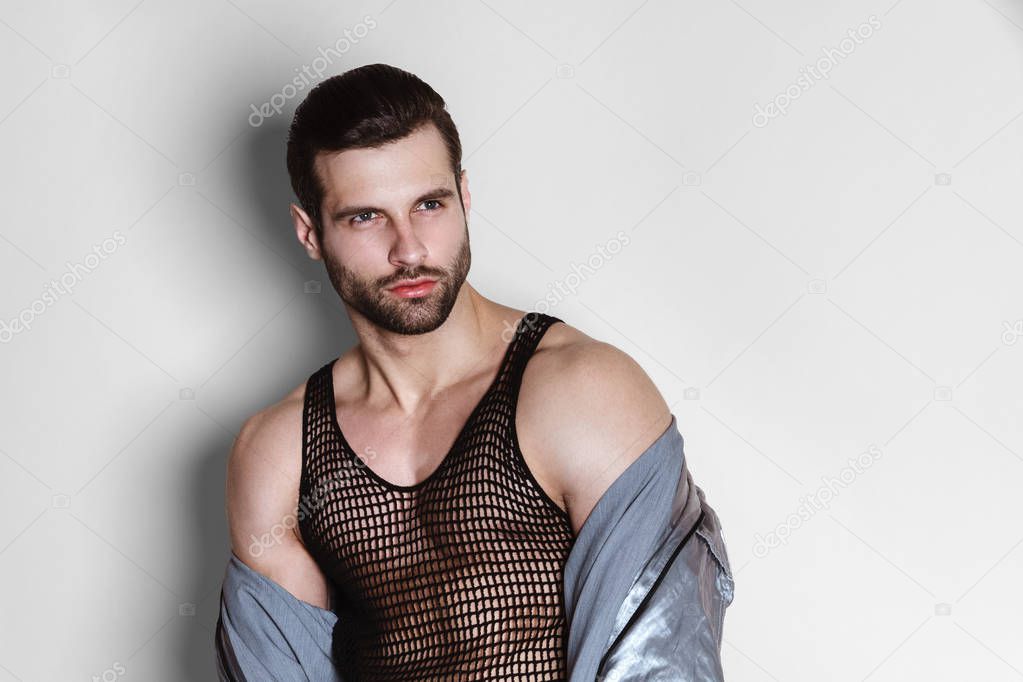 Muscle strong beautiful stripped male model in casual cloathes on white isolated font background
