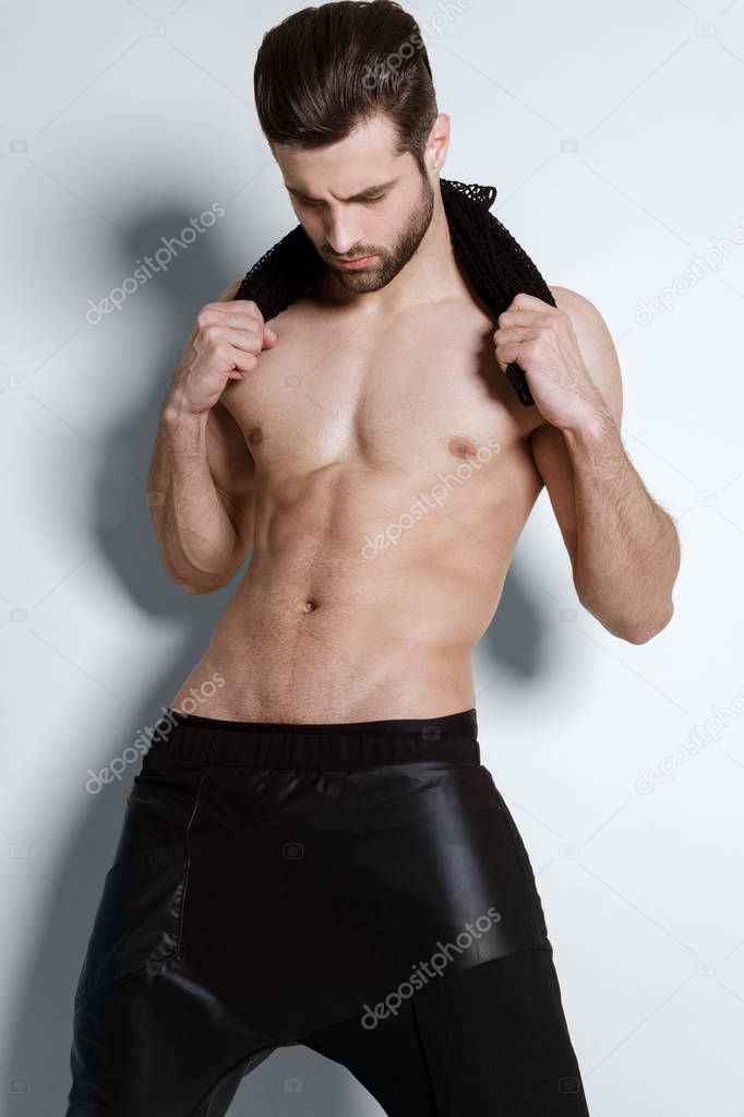 Muscle strong beautiful stripped male model in casual cloathes on white isolated font background