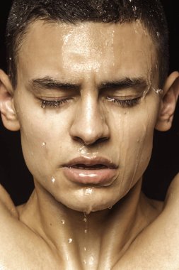 Yakışıklı seksi erkek portresi. Günlük giysiler ve iç çamaşırlarıyla su damlaları ve izole edilmiş siyah arka plan.