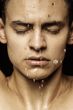 Yakışıklı seksi erkek portresi. Günlük giysiler ve iç çamaşırlarıyla su damlaları ve izole edilmiş siyah arka plan.