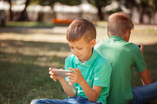 Милый Мальчик Сидящий Траве Парке Играющий Смартфоном Ребенок Учится Пользоваться — стоковое фото
