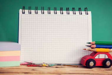 Minyatür kırmızı araba taşıyan bir renkli kalemler ve ahşap masa ve metin için yer kırmızı elma. Geri okul kavramı.