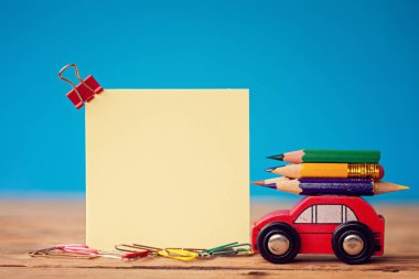 Metin için bir renkli kalemler-ahşap masa ve yer üzerinde taşıyan minyatür araba kırmızı. Geri okul kavramı.