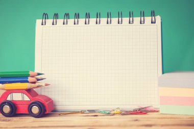 Minyatür kırmızı araba taşıyan bir renkli kalemler ve ahşap masa üzerinde kırmızı elma. Geri okul kavramı. Tonlama resim.