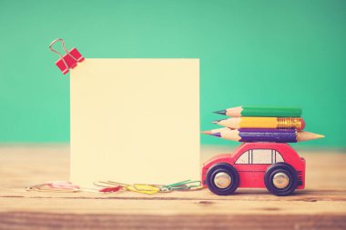 Geri okul kavramı. Minyatür kırmızı araba taşıyan bir renkli kalemler ve ahşap masa üzerinde kırmızı elma. Tonlama resim.