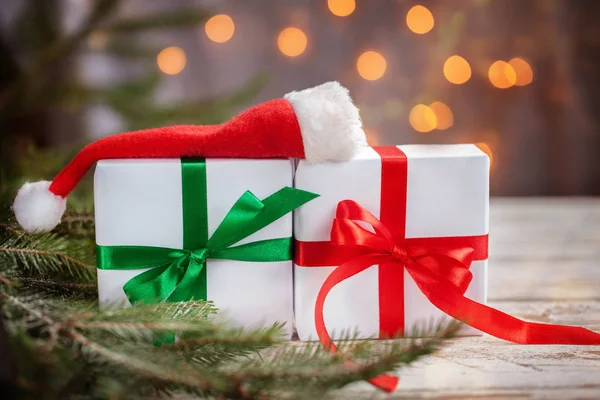 圣诞白盒子或礼物与圣诞老人帽子在白色木桌上 — 图库照片