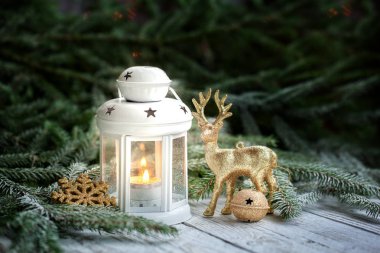 Fener, altın kar tanesi ve toplar, çam dalları ve süsler koyu arka plan üzerinde sıcak ışık koşullarında kış Noel dekorasyon