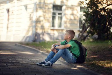 Yol açık havada parkta oturan üzgün yalnız çocuk