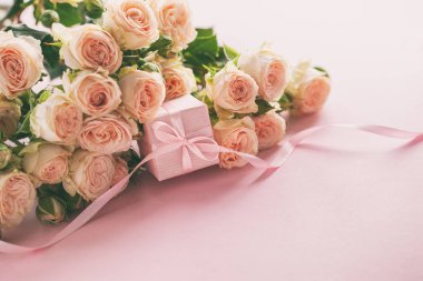 Pembe gül çiçek ve Hediyelik veya mevcut kutusu pembe arka plan. Anneler günü, Doğum günü, Sevgililer günü, Bayan gün, kutlama kavramı. Metin için yer.